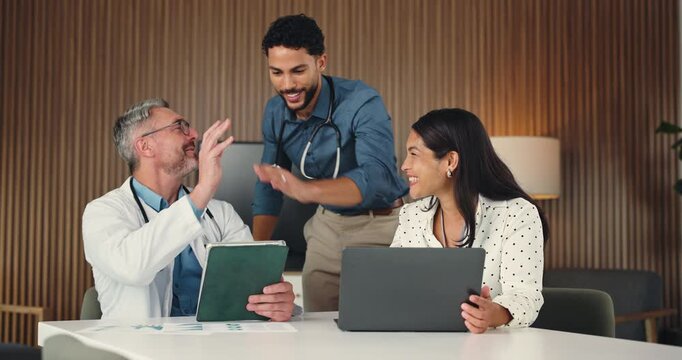 Excited, high five and doctors on tech in office for good news, achievement and medical funding. Healthcare, clinic and people with laptop, tablet and success for collaboration meeting and teamwork