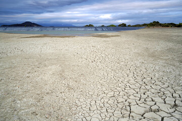 Cracked and dried mud in an empty dam, climate change image