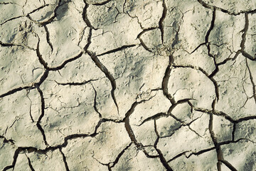 Cracked and dried mud in an empty dam, climate change image
