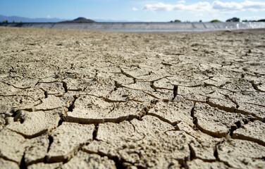 Cracked and dried mud in an empty dam, climate change image