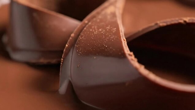 Close up of rich dark chocolate curls and swirls, showcasing its smooth texture and delicious appearance for gourmet desserts