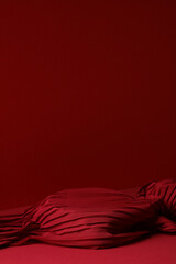 Minimalist red background with pleated fabric texture and copy space for product placement