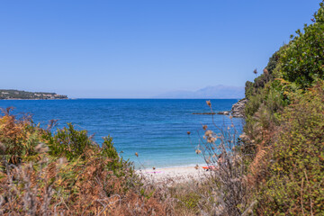View of tranquil turquoise beach cove with distant mountains