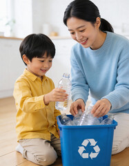 Happy asian mother and son sorting plastic bottles in recycling bin at home