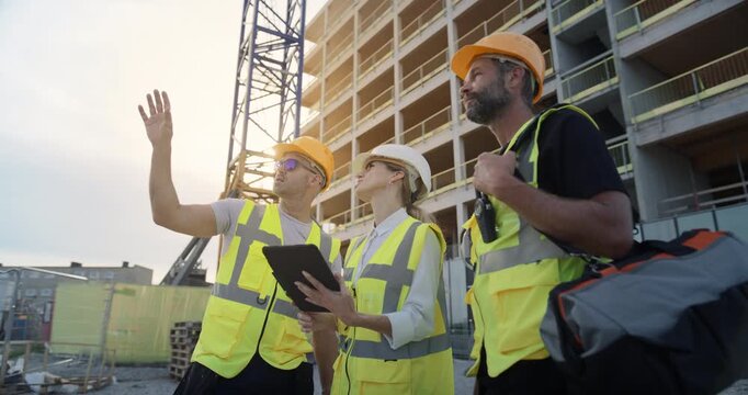 Professional Engineers and Construction Managers Review Digital Blueprints on a tablet, Commercial and Residential Building Development,Real Estate Construction of High-rise House