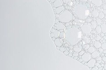 The texture of the foam of shower gel or soap suds or shaving foam. Cosmetic skin care product. Macrophotography. Copy space