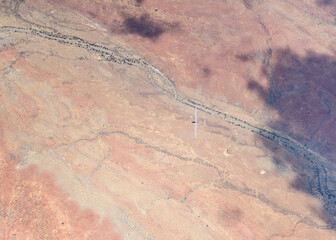 glider in flight above creek dry river bed in desert, near Nomtsas, Namibia