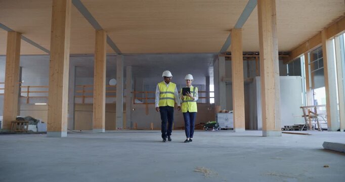 Engineers Walk Through Commercial Building Under Construction, Reviewing Structural Details and Discussing Quality Standards, Sustainable Real Estate Development, Business or Residential Property 