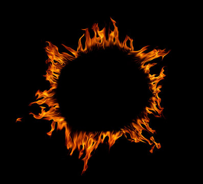 Burning fire ring frame isolated on black background with glowing flames forming a circular border. Dramatic fire effect for power, danger, energy, heat, abstract design, and copy space concept.
