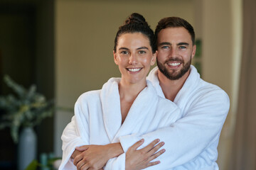 Portrait of mid adult couple hugging in bathrobe at spa