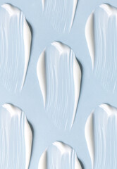 pattern of cream smears of creamy texture on blue background