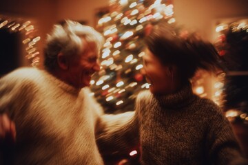 A blurred image capturing a joyful moment between two people celebrating with a festive Christmas tree in the background.
