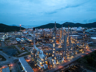 Aerial drone view of petrochemical oil refinery plant with blue night lights for chemical engineering industry and fuel energy business logistic infrastructure concept.