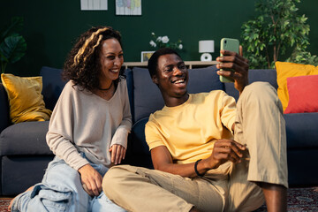 Happy young multiracial couple video calling on smartphone
