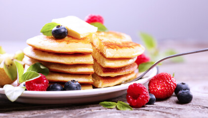 delicious stack of pancakes with butter and fresh berries fruits
