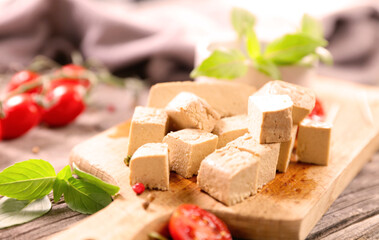fresh tofu cubes on wooden board