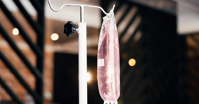 Therapy, IV bag and drip in lounge for health benefits, saline solution and immune system boost. Bokeh, intravenous infusion and medical fluid at wellness center for nutrition, detox and electrolytes