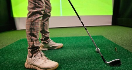 Professional female golfer playing golf indoors on golf simulator closeup