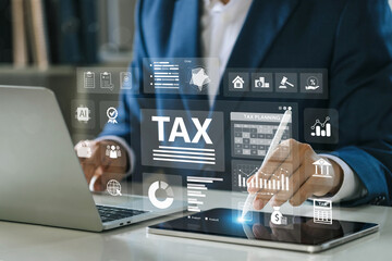 Tax planning concept with a professional using a laptop and tablet, digital dashboard, financial analysis, accounting system, corporate strategy, investment, and smart tax management technology.