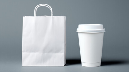 White paper bag and disposable coffee cup set on grey background. Items are blank for custom branding and design. Useful for food and beverage service