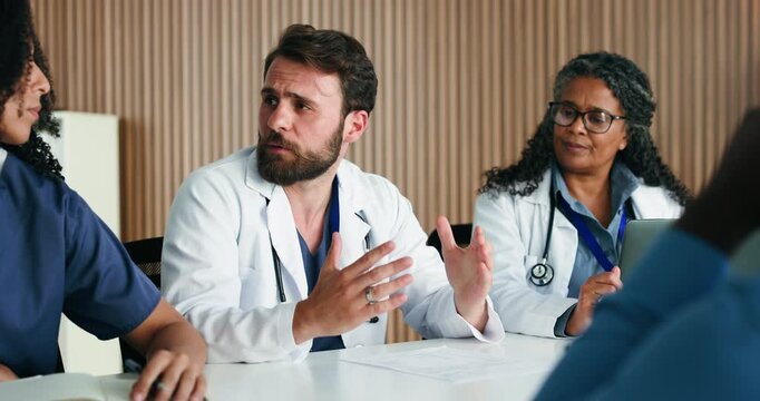 Man, talking and doctors in clinic, healthcare and feedback for team schedule. People, medical service and employees with discussion, meeting or review for medicare compliance and hospital agenda