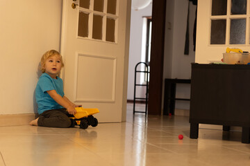 Young boy playing with toy truck on floor