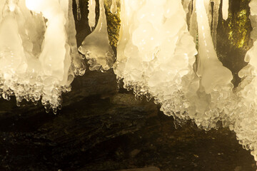 Large Stalactite-Shaped Icicles Hanging in Dark Winter Cave