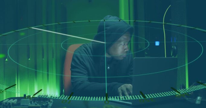 Using laptop with animation of digital radar, hacker in hoodie working