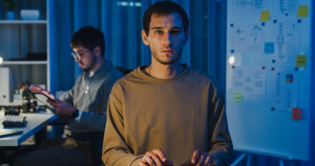 Team adult male freelance developer work late typing write prompt AI bot app program nomad terminal code at office night. Artificial intelligence dashboard, robotics, user interface, machine learning.