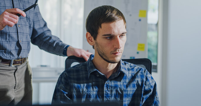 Team adult male engineer collaborate on robotic hand project using AI code solutions machine learning at tech workspace. Artificial intelligence interface, collaboration support prototype development.