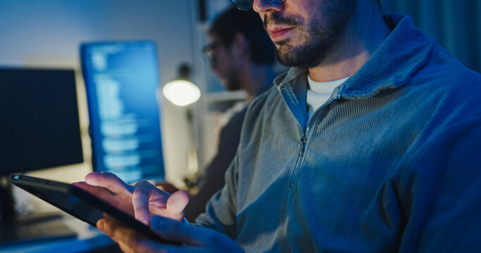 Team adult male freelance developer work late use tablet write prompt AI bot app program nomad terminal code at office night. Artificial intelligence dashboard, robotics, interface, machine learning. - Powered by Adobe