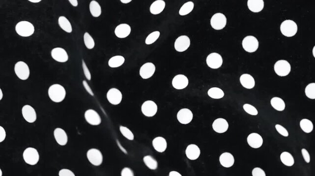 Black fabric with white polka dots pattern abstract background texture