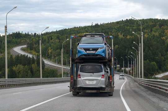 IRKUTSK REGION, RUSSIA - SEPTEMBER 07, 2025: Car carrier with passenger cars on the highway, Irkutsk Region