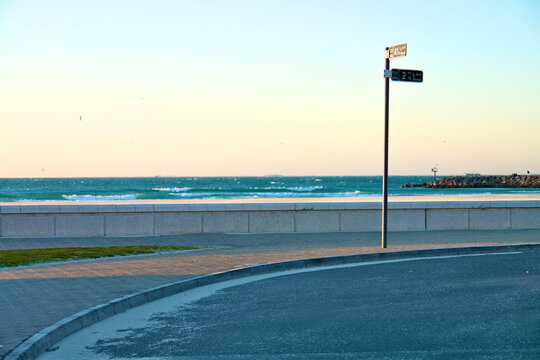 Street sign at Jumeirah Beach in Dubai with empty promenade