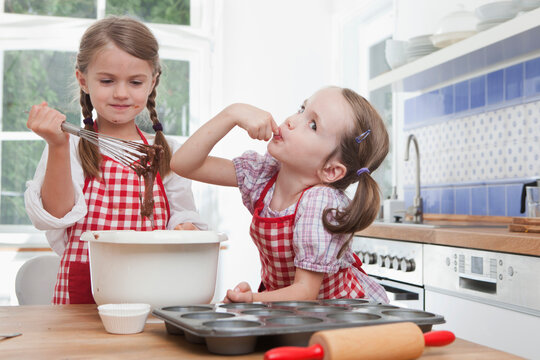Children baking cookies together in a bright kitchen in Munich