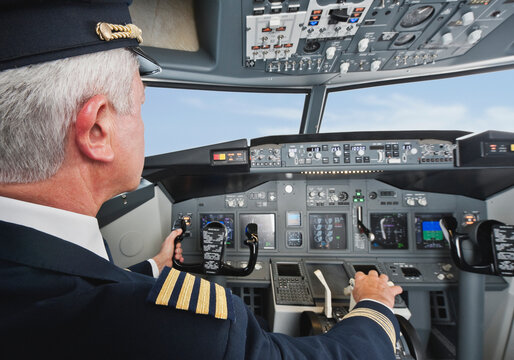 Airline captain in uniform operating airplane cockpit in Munich