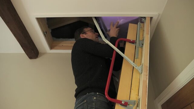 4K: A Man getting the Christmas Decorations in a box down from the Loft or Attic. Stock Video Clip Footage.