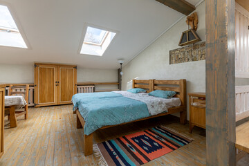 Cozy rustic attic bedroom with wooden bed and skylights