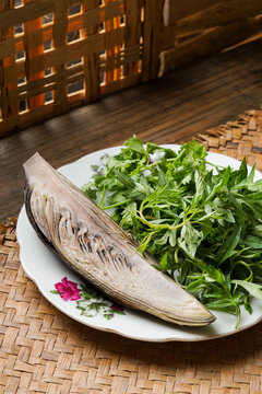 This traditional Malay ulam features fresh ulam raja coriander leaves and boiled banana blossom served as a healthy raw and lightly cooked herb platter commonly enjoyed with rice and sambal in home co