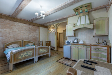 Rustic studio apartment interior with painted beds and olive kitchen