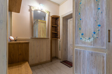 Rustic hallway interior with hand-painted wardrobe and wooden door