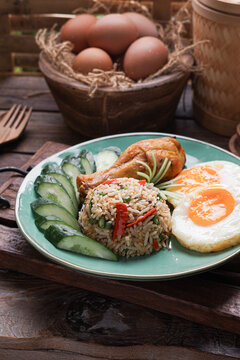 Nasi Goreng served with fried egg fried chicken and fresh cucumber ulam is a classic Southeast Asian meal combining savory flavors, crispy textures, and traditional home cooked comfort food.