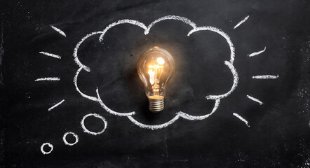 Glowing light bulb inside a chalk-style thought bubble on dark background, symbolizing creative thinking, innovation, idea generation, imagination, problem solving, education concepts, and strategic p