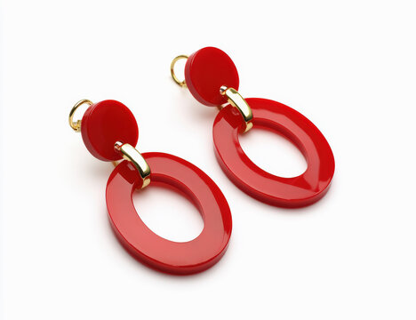Pendientes rojos ovalados en forma de aro con apliques dorados sobre fondo blanco. Accesorios flamencos para vestidos regionales y fiestas de la cultura andaluza en Espa&ntilde;a