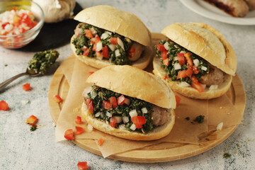 Choripan - bread with grilled sausages with chimichurri sauce, traditional Argentinian fast food dish	