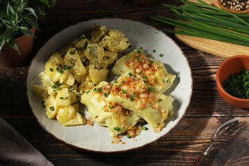 Traditional Swabian dish Maultaschen served with roasted onion and potato salad	