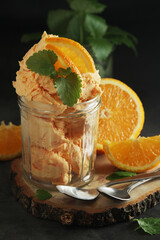Orange ice cream scoops in glass jar