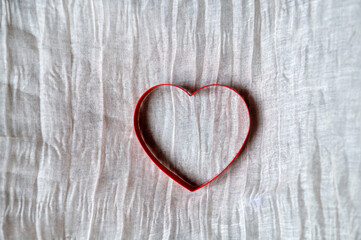 top view of red heart on beige background with copy space.