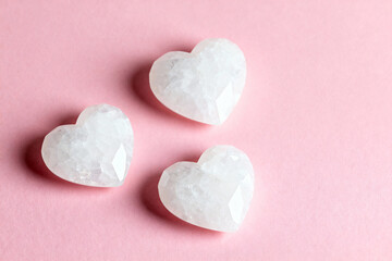 Fototapeta premium White cristal shaped hearts, on a soft pink background. Valentin's Day.