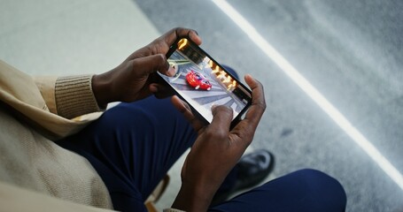Mobile phone with online game in male hands